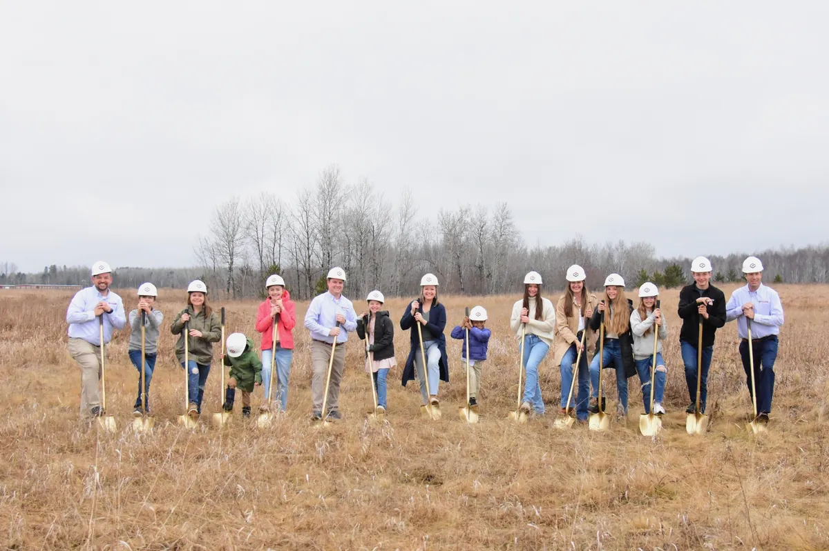 Collins Roofing team and families at the groundbreaking ceremony for the new Cloquet facility — Collins-branded hardhats and ceremonial gold shovels