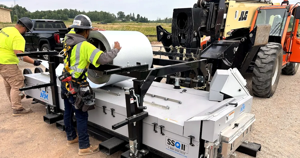 Collins crew loading a steel coil onto the on-site standing seam roll-former at a Northern Minnesota jobsite